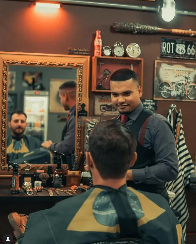Barbeiro atendendo cliente em frente ao espelho